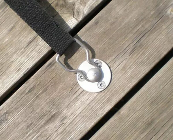 Ein Versenkbarer Bodenanker aus Edelstahl (12 mm) wird mithilfe von Schrauben sicher auf einer verwitterten Holzoberfläche befestigt, wodurch die natürliche Maserung und Struktur hervorgehoben wird.