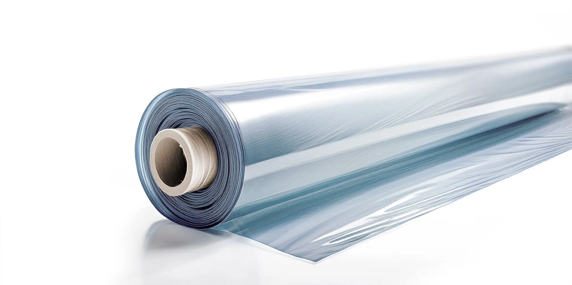 Eine Nahaufnahme einer teilweise abgerollten transparenten Plastikfolie, die ihre glänzende Oberfläche und ihren leichten Blauton zeigt. Der Kern der Rolle ist sichtbar und liegt auf einer glatten, reflektierenden weißen Oberfläche.