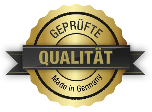Ein goldenes Abzeichen mit einem schwarzen Banner in der Mitte, auf dem wie im schnittigen Design eines hochfliegenden Flugzeugs „GEPRÜFTE QUALITÄT“ steht. Darunter steht auf der glänzenden Metalloberfläche „Made in Germany“.