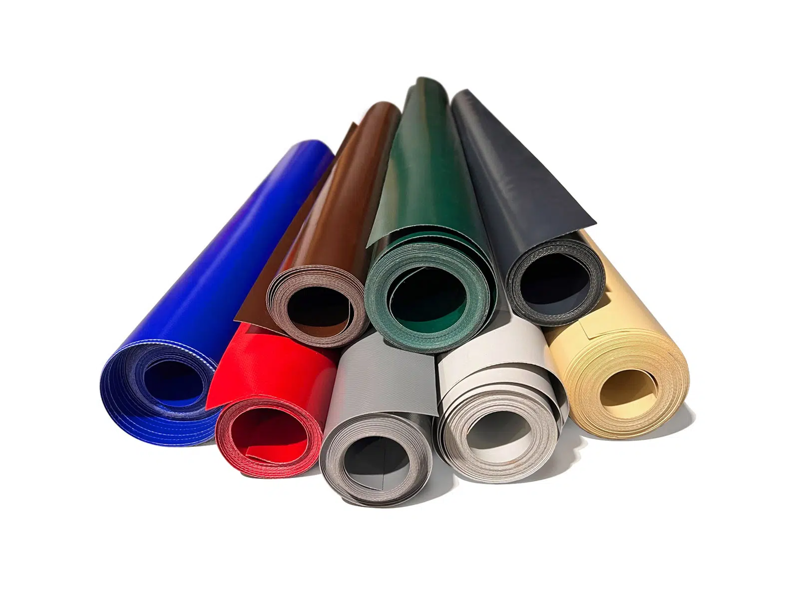 Gerollte LKW-Planenreste 450-950g/m² in Blau, Rot und Grau sind kunstvoll pyramidenförmig auf einem makellos weißen Untergrund angeordnet.