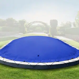 Ein rundes Outdoor-Trampolin mit einer blauen Sicherheitsabdeckung, wie das Ovale aufblasbare Poolplanen, wird mit Bungee-Seilen auf einer Wiese mit einem Garten und Torbögen dahinter befestigt.