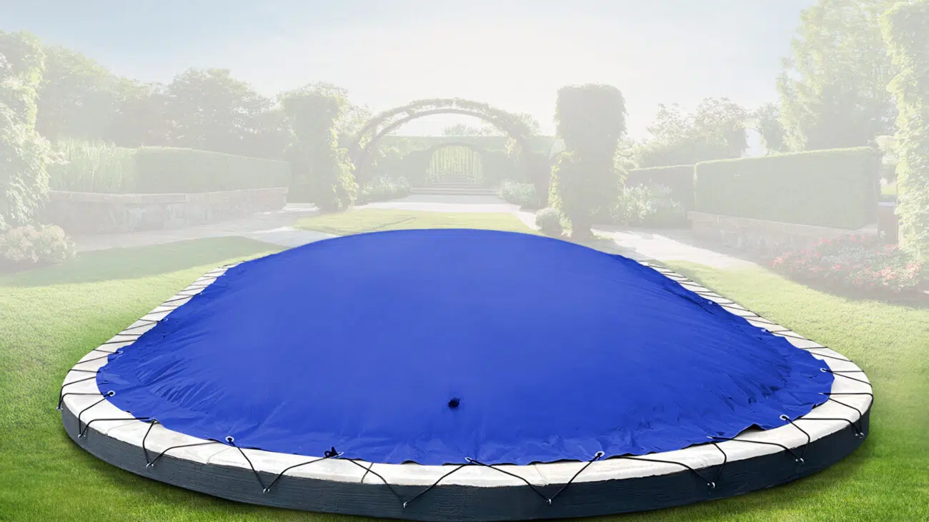 Eine ovale aufblasbare Poolplane (Sondermaß) bedeckt den Pool auf dem Holzdeck, mit einer grünen Hecke, Gras und zwei Topfpflanzen in der Nähe.