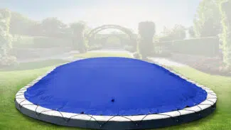 Eine ovale aufblasbare Poolplane (Sondermaß) bedeckt den Pool auf dem Holzdeck, mit einer grünen Hecke, Gras und zwei Topfpflanzen in der Nähe.