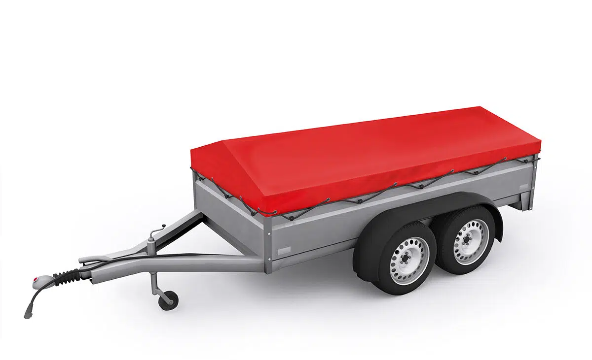 Präsentiert wird ein silberner zweiachsiger Nutzanhänger mit Zwillingsrädern, der über eine verlängerte Anhängerkupplung verfügt. Er ist mit einer straff gespannten, leuchtend roten Anhängerplane bedeckt und steht vor einem schlichten weißen Hintergrund.