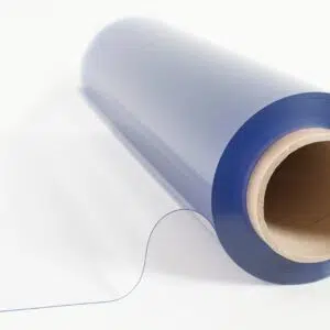 Eine Rolle MUSTER PVC Plane/Folie-Transparent Classic rollt sich teilweise auf einer weißen Oberfläche ab. Die Folie um eine Pappröhre glänzt im Licht und hebt ihre glatte Textur hervor.
