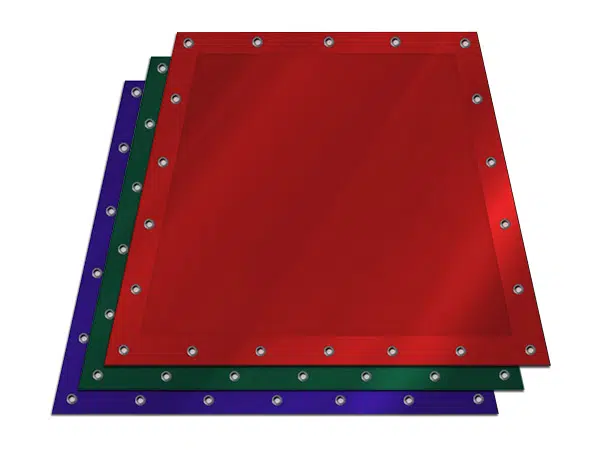 Drei übereinander gestapelte PVC-Platten aus der Serie PVC Plane in Trapezform zeigen metallisch besetzte Kanten. Die obere Platte ist rot, die mittlere grün und die untere blau, wobei Schatten einen 3D-Effekt erzeugen.