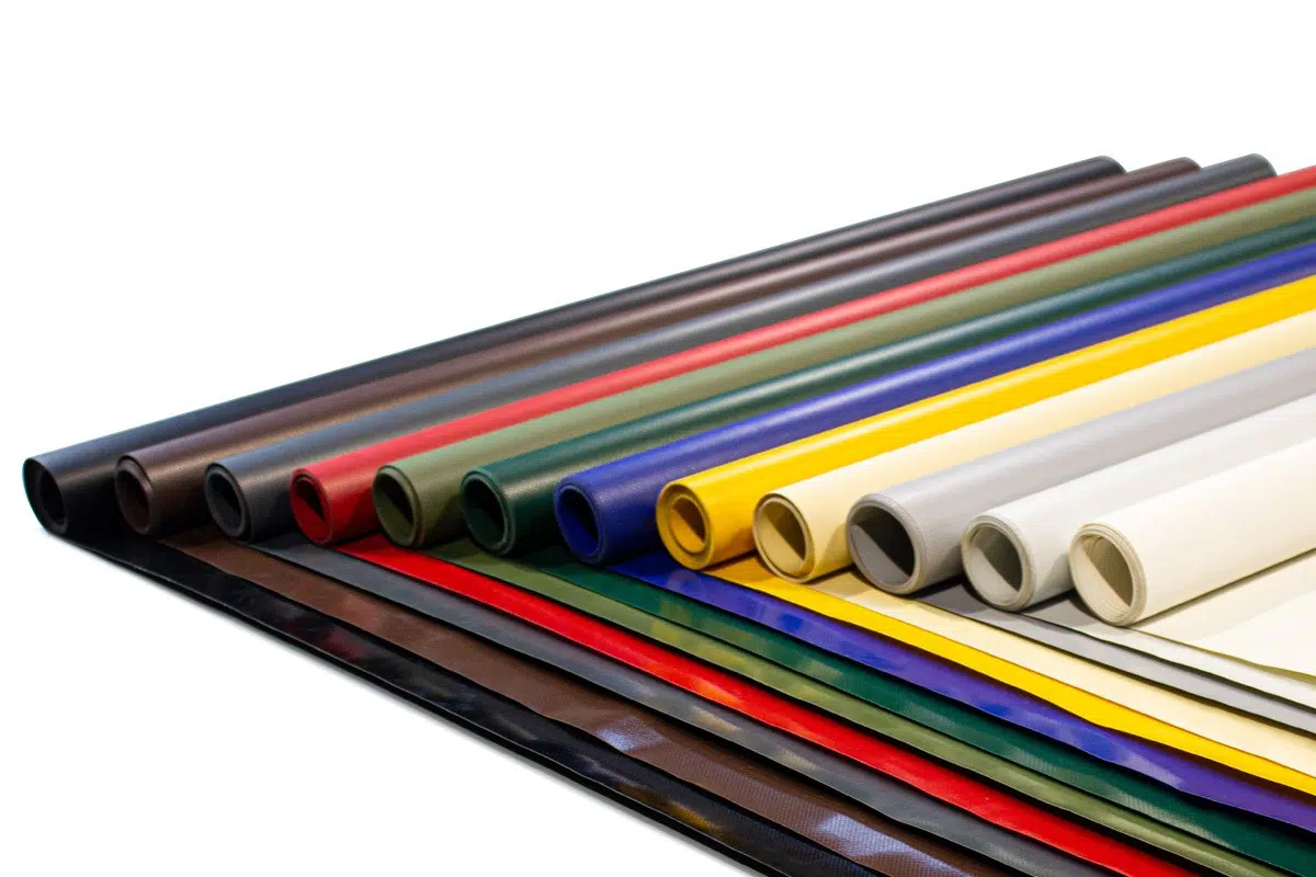 An LKW-Planen erinnernde gerollte Blätter aus Kunstleder sind in verschiedenen Farben – Braun, Grün, Blau, Rot, Gelb, Grau und Weiß – erhältlich und fächerartig kunstvoll auf einer flachen Oberfläche angeordnet.