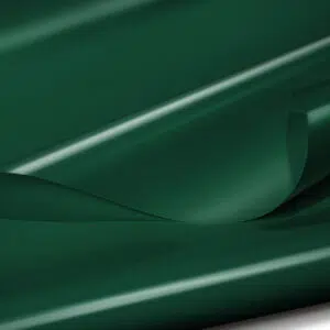 Eine Nahaufnahme einer Platte aus dunkelgrünem Kunststoff mit glänzender Oberfläche, die sanfte Rundungen und eine leichte Lichtdurchlässigkeit aufweist, wodurch auf der Oberfläche subtile Glanzlichter und Schatten entstehen.