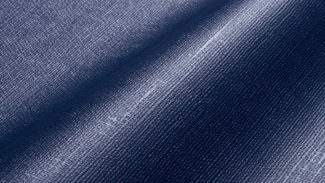 Nahaufnahme eines blauen Denim-Stoffes mit Webstruktur und leichtem Glanz, ähnlich wie MEHGIES® VALMEX® Solera Vorzeltplane. Seine sanften Falten erzeugen weiche Schatten und betonen das Zusammenspiel von Licht und Struktur.