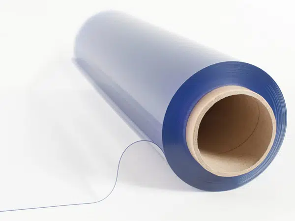 Eine Rolle glatter, blauer PVC-Planenfolie wird teilweise auf einer weißen Oberfläche abgerollt. Die halbtransparente Folie betont ihre Dünnheit und Flexibilität, wobei in der Mitte der Kartonkern sichtbar ist.