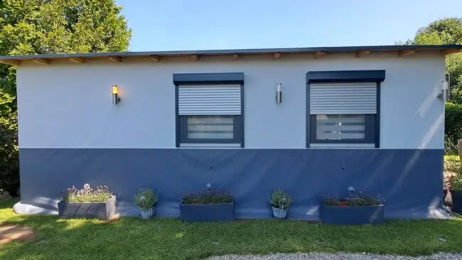 Vorzeltverkleidung in Blau und Weiß mit Fenstern und geschlossenen Rollläden.