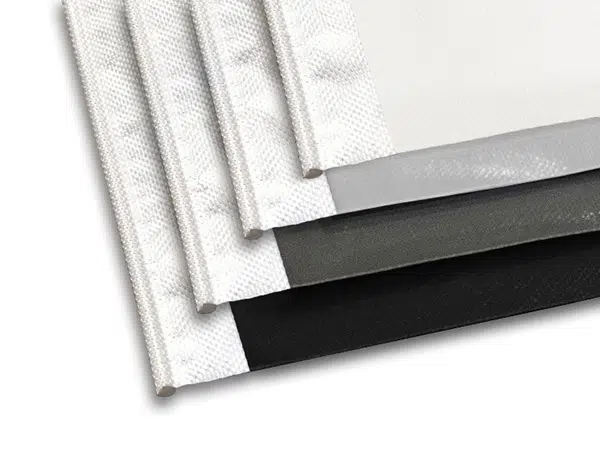 Ein Stapel aus vier rechteckigen Stoffmustern, perfekt für Campingausrüstung, in verschiedenen Farbtönen von hell bis dunkel. Die ausgerichteten Kanten zeigen die strukturierte Oberfläche und die sorgfältigen Nähte.