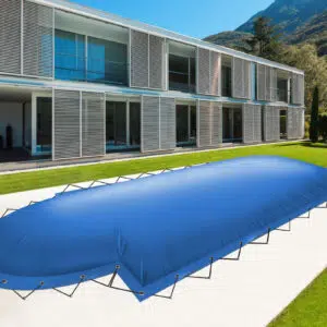 Ein modernes zweistöckiges Gebäude mit großen Fenstern überblickt einen Pool im Hinterhof mit rechteckigen aufblasbaren Poolplanen (+römische Treppe), vor einem grünen Rasen und einer atemberaubenden Berglandschaft.