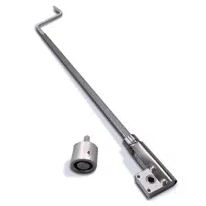 Eine Rollfix-Kurbel-Handkurbel mit einer Metallstange, die an einem Ende gebogen und an einem zylindrischen Teil befestigt ist, liegt auf einer weißen Oberfläche. Daneben befindet sich ein kleines zylindrisches Stück mit einem Loch in der Mitte.