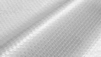 Nahaufnahme einer 550 g/m² PVC-Folie, 2,18 m breit, durchscheinend mit Gittergewebe. Die leichte Welligkeit erzeugt ein Wechselspiel aus Licht und Schatten und hebt die detaillierte Textur hervor.