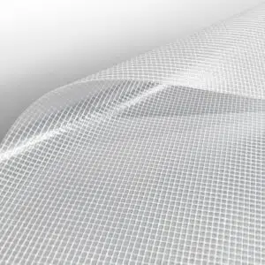 Nahaufnahme eines flexiblen, transparenten Materials mit Gittermuster, leicht gekrümmt wie eine Ebene nach Maß. Die glänzende Oberfläche hebt die Textur hervor, vor einem weißen Hintergrund, der ins Grau übergeht und so für einen minimalistischen Look sorgt.