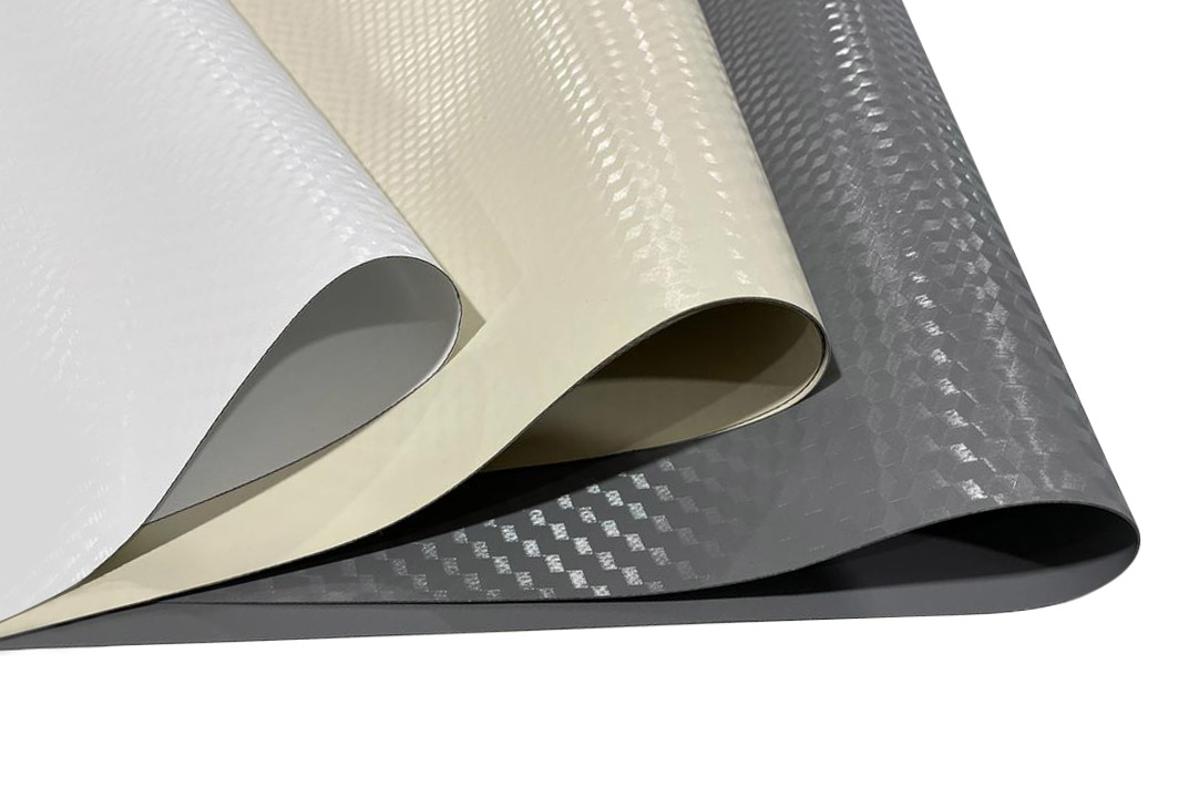Nahaufnahme von drei überlappenden Materialblättern. Die Blätter sind strukturiert und gewellt, wobei jedes eine eigene Farbe hat: Weiß, Beige und Grau. Die Oberflächen haben eine reflektierende Oberfläche, die ihre Struktur hervorhebt.