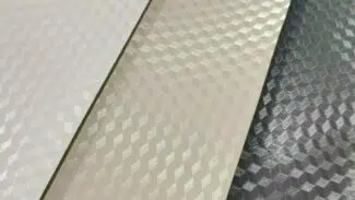 Nahaufnahme von drei strukturierten 3D-Oberflächen mit einem Wabenmuster in Weiß, Beige und Silber, die reflektierende geometrische Designs aufweisen, die der hochwertig beschichteten (850 g/m²) PVC-Folie – 2,5 m breit mit 3D-Prägung – ähneln.