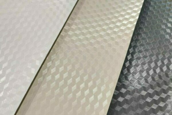 Nahaufnahme von drei strukturierten 3D-Oberflächen mit einem Wabenmuster in Weiß, Beige und Silber, die reflektierende geometrische Designs aufweisen, die der hochwertig beschichteten (850 g/m²) PVC-Folie – 2,5 m breit mit 3D-Prägung – ähneln.