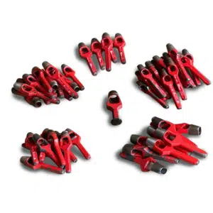 Kreisförmig angeordnete rote Metallstifte, die als Zeichen der Gebrauchsspuren leicht verwittert sind, sind um einen Mittelstift gruppiert. Produkt: Einschlagstempel (Ösenwerkzeug) -Gebraucht-.