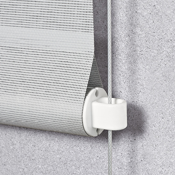 Nahaufnahme eines teilweise ausgerollten grauen Rollos, das auf einer weißen Halterung vor einer strukturierten grauen Wand montiert ist und in seinem modernen Design an elegante Senkrechtmarkisen erinnert.