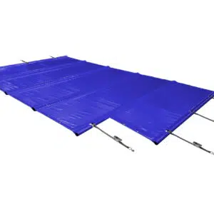 Ein modernes weißes Haus mit großen Fenstern und einem Flachdach verfügt über eine Terrasse mit blauen Poolplanen in L-Form (Stangenabdeckung), Gartenmöbeln, Grünanlagen und hohen Bäumen vor einem klaren Himmel.