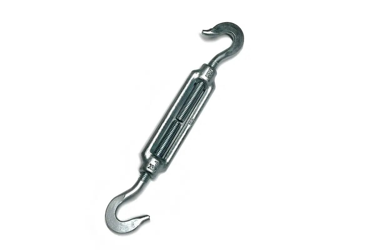 Der Ratschen-Spanngurt ist ein Spannschloss aus Metall mit Haken an beiden Enden und einem zentralen Gewinde zur Spannungseinstellung, auf weißem Hintergrund.