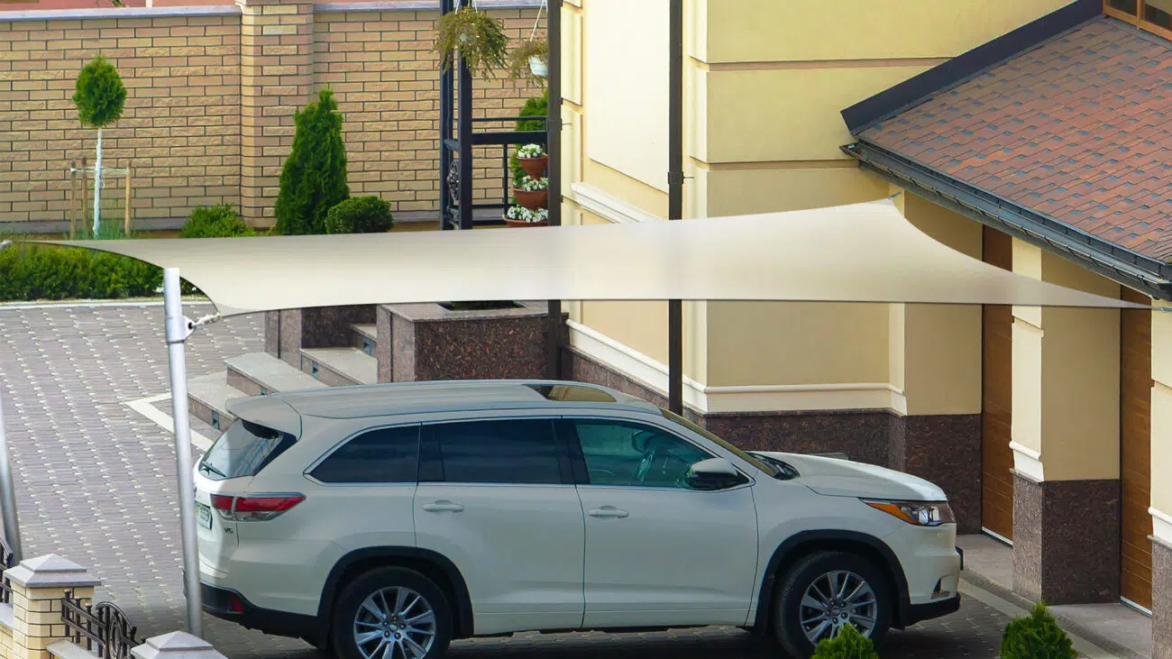 Ein Auto in einer Auffahrt im Schatten eines Sonnensegels