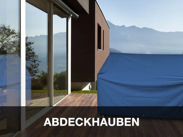 Dieses moderne Haus liegt in einer malerischen Berglandschaft und verfügt über große Glasfenster. Die Terrasse ist mit blauen Gartenmöbeln ausgestattet, die mit einem LKW-Flugzeug bedeckt sind, und unten ist deutlich „ABDECKHAUBEN“ darübergelegt.