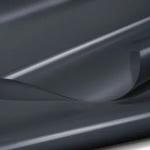 Eine Nahaufnahme eines glänzenden, dunkelgrauen Stoffes mit glatter Textur. Der Stoff ist leicht gefaltet, wodurch sanfte Kurven und ein Gefühl von Tiefe entstehen. Die Beleuchtung hebt den Glanz und die subtilen Reflexionen des Materials hervor.
