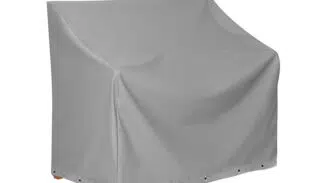 Die Abbildung zeigt eine rechteckige, graue Abdeckhaube für Gartenmöbel vor einem weißen Hintergrund. Die Abdeckhaube ist im unteren Bereich mit Ösen versehen.