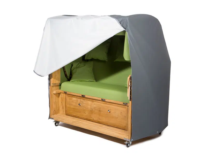Ein grün gepolsterter Sitz mit Holzrahmen und Stauraum darunter, teilweise bedeckt von einem grau-weißen Baldachin. Das Stück steht auf Rädern für Mobilität und bietet mit seiner Abdeckhauben-Funktion Komfort und Schutz.
