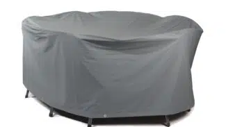 Eine große, graue, rechteckige Abdeckhaube deckt Gartenmöbel ab und zeigt ihre Umrisse. Diese robuste Abdeckung ist zum Schutz mit Ösen an der Unterseite befestigt.