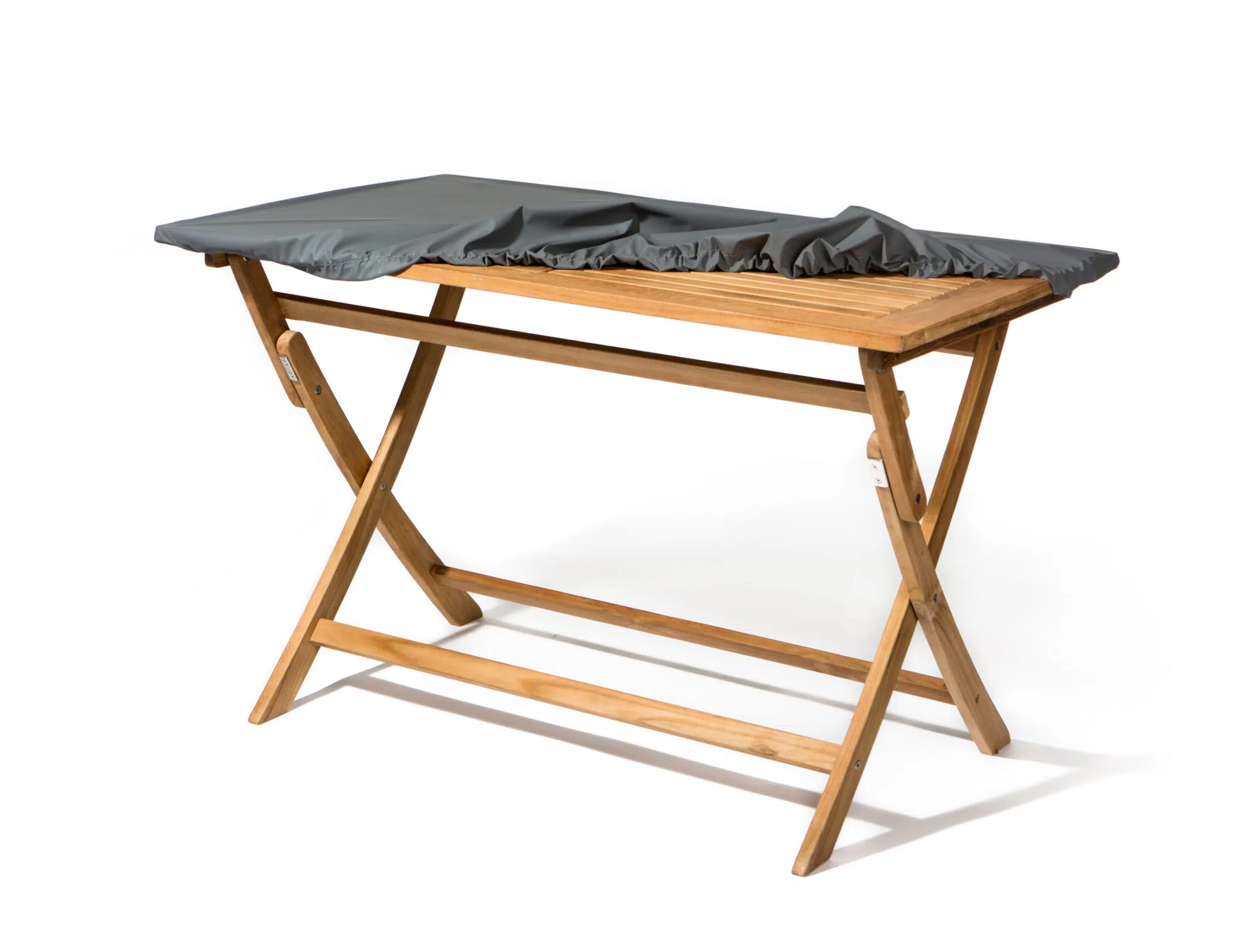 Holztisch mit klappbaren Beinen, dessen Tischplatte teilweise mit einem dunkelgrauen Stoff bedeckt ist. Vor einem schlichten weißen Hintergrund.