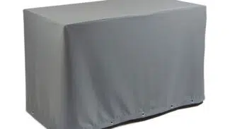 Eine Tischhaube eckig in grau (Teak Safe) deckt einen Tisch vor einem weißen Hintergrund ab. Die Ösen an der Unterseite sorgen für einen sicheren Sitz.