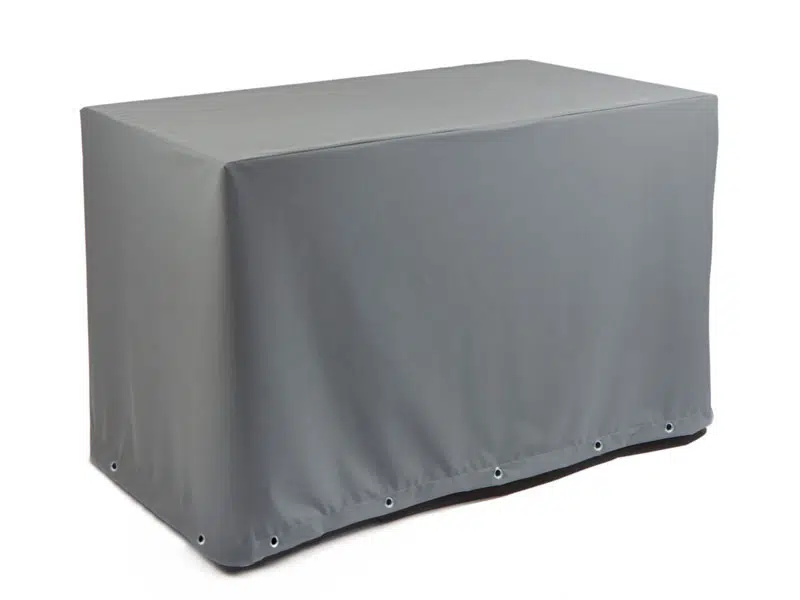 Eine Tischhaube eckig in grau (Teak Safe) deckt einen Tisch vor einem weißen Hintergrund ab. Die Ösen an der Unterseite sorgen für einen sicheren Sitz.