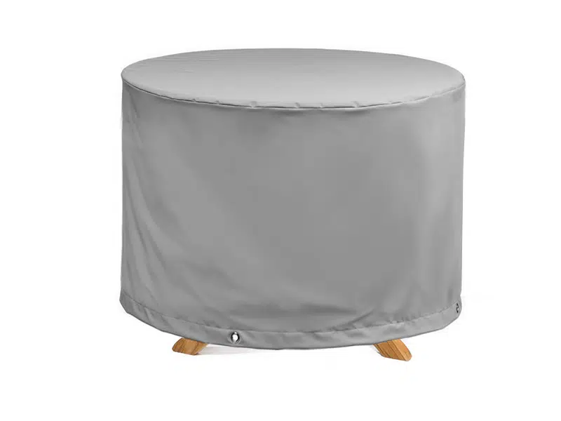 Das Bild zeigt eine runde, graue Abdeckhaube für Gartenmöbel. Die Abdeckung ist mit Ösen im unteren Bereich versehen, um sie an den Möbeln zu befestigen. Der Hintergrund ist weiß.