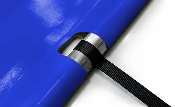 Nahaufnahme einer blauen Plane mit einer Metalltülle und einem schwarzen Band, das durch die Öffnung gezogen ist, vor einem weißen Hintergrund.