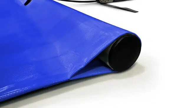 Nahaufnahme einer aufgerollten blauen Plane mit einem schwarzen Gurt und einer Metallratsche auf einer weißen Fläche.