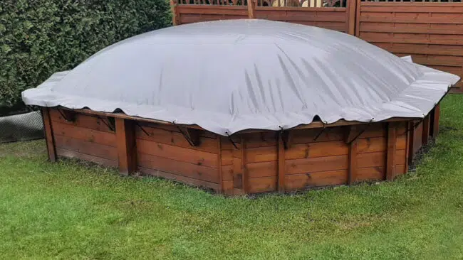 Eine Holzkonstruktion mit einer Plane darauf.